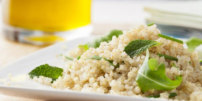 Quinoa with green leaves in a white dish