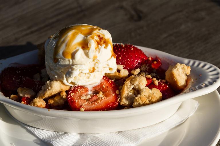 a dish of strawberry-rhubarb crisp topped with ice cream
